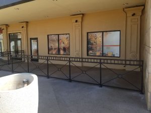Decorative black wrought iron fencing encloses restaurant patio