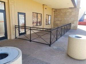 Black wrought iron fencing encloses restaurant patio