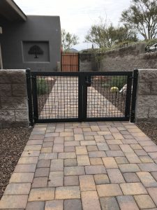 Black wrought iron gate secures a home's front courtyard.