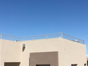 Wrought iron view fencing encloses a home's rooftop deck.