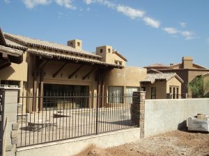 Wrought iron view fencing secures a home's backyard.