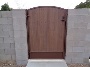 A wood and wrought iron gate secures a home's yard.