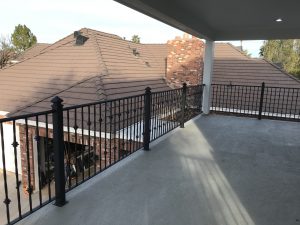 Black wrought iron railing secures a home's second-floor patio