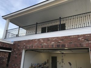 Black wrought iron railing secures a home's second-floor balcony