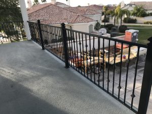 Wrought iron railing secures a home's upstairs patio