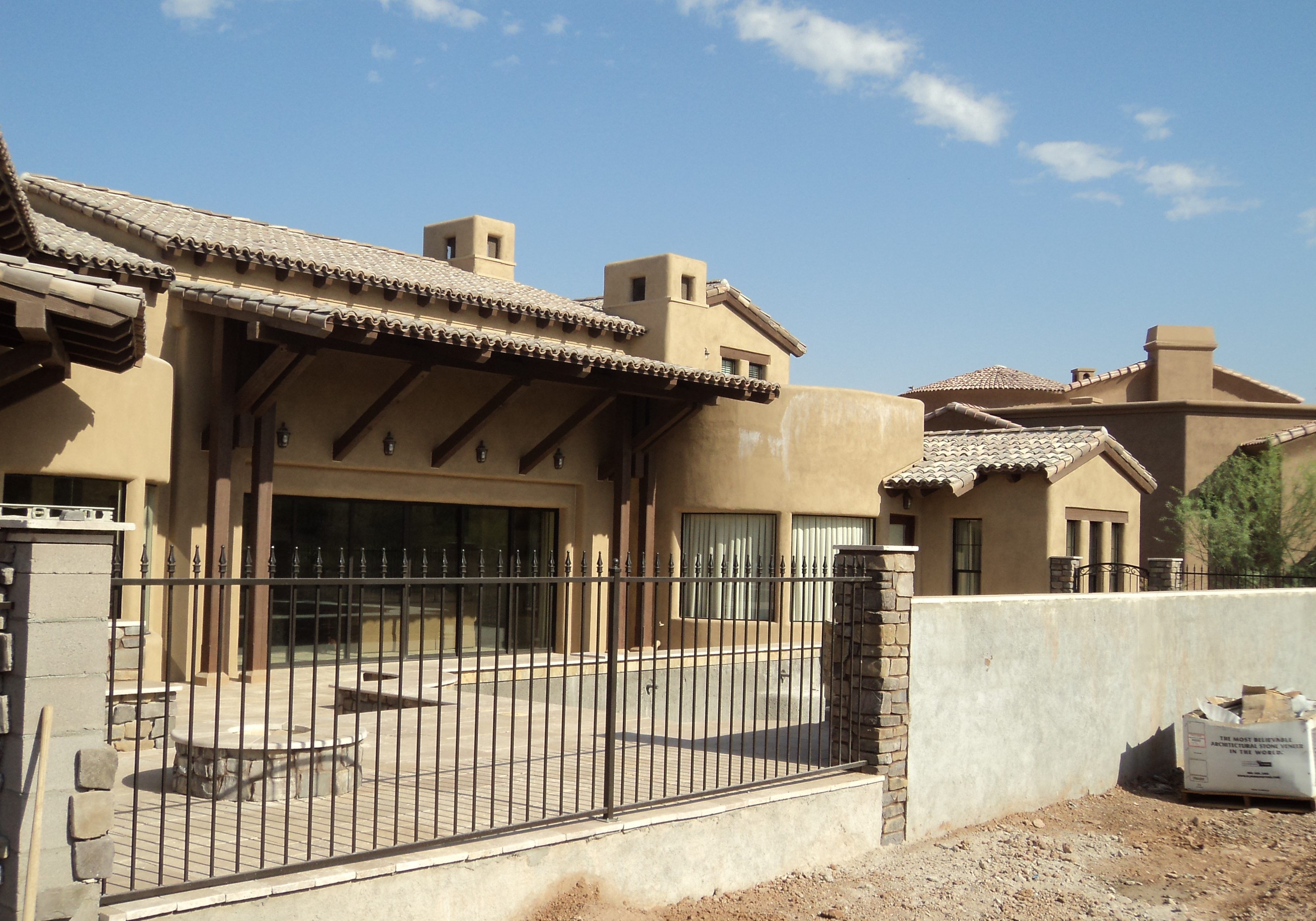 Wrought iron view fencing secures a home's backyard.